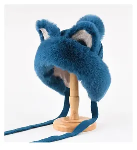 Close-up of blue plush trapper hat with cat ears and warm knit straps on wooden stand