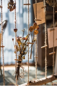 Detail of natural dried rose bouquet hanging on hemp rope with small wooden clips