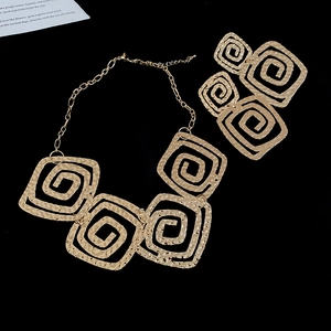 Close-up of golden geometric square jewelry set with elegant hammered texture finish