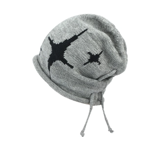 Detail of grey knitted beanie with black star jacquard and decorative drawstring cord