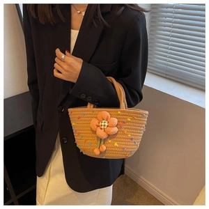 Detail of khaki woven cotton rope handbag featuring colorful floral embroidery and 3D orange flower