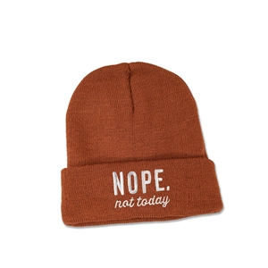 Detail der karamellfarbenen Strickmütze mit weißem NOPE. not today Stickerei-Schriftzug