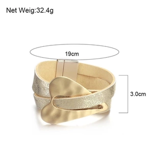 Detail showing wide gold leather bracelet dimensions with 19cm length and heart charm