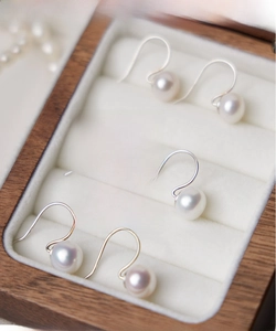 Three pairs of white 8-9mm freshwater pearl earrings in a wooden velvet jewelry box