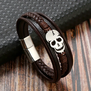 Close-up of brown braided leather skull bracelet with a secure silver magnetic clasp
