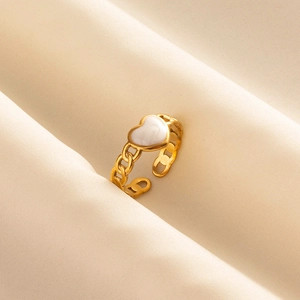 Golden heart ring with white inlay and chain band design on silk background