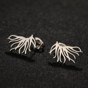 Macro shot of silver-tone stainless steel tree root earrings on black background