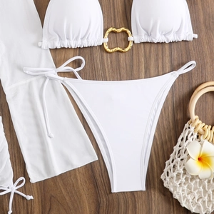 White bikini set with gold heart ring detail and mesh cover-up on wooden background