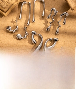 Close-up of irregular liquid metal titanium steel earrings with vacuum plating finish