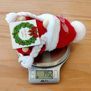 Detail of red knit Christmas gnome decoration with glasses weighing 145.2g on a scale