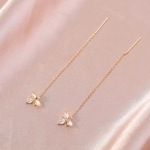 Detail of rose gold flower drop earrings with marquise cubic zirconia on satin