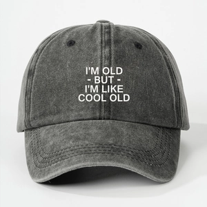 Close-up of I'M OLD BUT I'M LIKE COOL OLD slogan on washed charcoal denim baseball cap