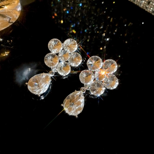 Macro shot of sparkling flower drop earrings with silver finish and pear-cut crystal charms
