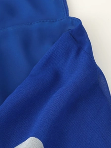 Vue macro détaillée de la texture du tissu mousseline bleu roi avec couture sur la robe