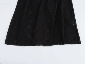 Close-up detail of the black lace crochet pattern and mesh texture on the beach maxi dress