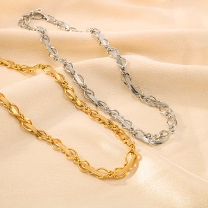 18K gold and silver flat snake chain necklaces on soft beige silk background