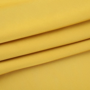 Gros plan sur le tissu en satin jaune vif montrant les plis doux et la texture de la robe