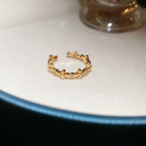 Macro detail of 18k gold plated adjustable ring with zircon cross flower patterns