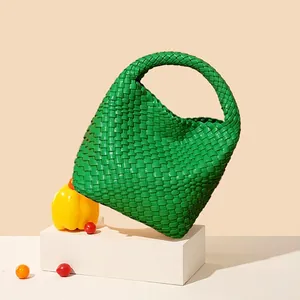 Bright green hand-woven leather tote bag in a minimalist semi-circular design