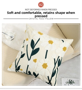 Close-up of floral daisy embroidery on soft white crystal fuzz decorative pillow cover