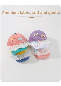 Detail of children's cotton sun caps featuring lace edges, colorful bows, and pearl accents
