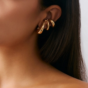 Detailed side view of a gold fluid metal ear cuff with a glossy lava style finish