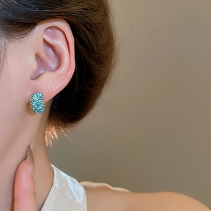 Close-up of model wearing square sea-blue zircon earrings with 18k gold plating