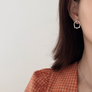 Irregular textured 925 sterling silver hoop earrings worn by a model in a minimalist style