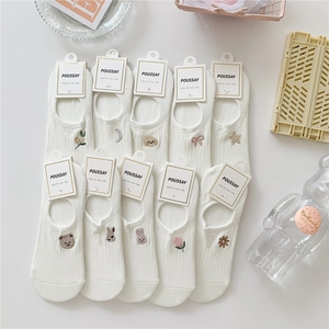 Flat lay of ten pairs of white cotton no-show socks with colorful animal embroidery