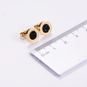 Detailed size view of gold Roman numeral earrings with black crystal inlay on scale