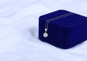 Makroaufnahme von Silber Shamballa Kristallkugel Anhänger auf blauer Samt Schmuckschatulle