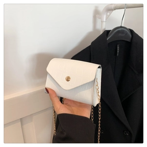 Detail of white crocodile embossed PU leather crossbody bag with gold chain strap