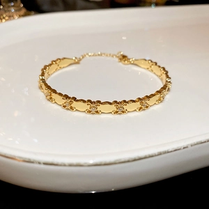 Macro detail of 18k gold plated iris bangle with sparkling zircons and lobster clasp