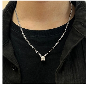 Close-up of Figaro chain necklace with a square moissanite pendant on a person