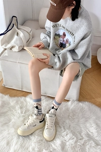 Detailed close-up of mid-calf socks with cat embroidery and chic vintage sneakers