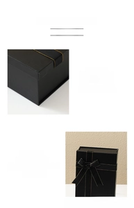 Close-up of black matte gift box with elegant gold-edged ribbon and texture details