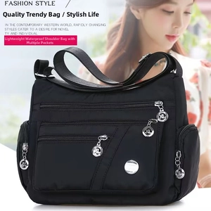 Dettaglio della borsa a tracolla in nylon nero impermeabile con diverse tasche a zip