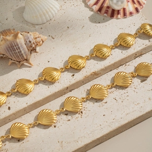 Dettaglio dei maglioni dorati a forma di conchiglia su base di pietra decorativa