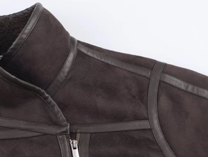 Close-up of brown suede jacket with faux leather trim and soft shearling collar