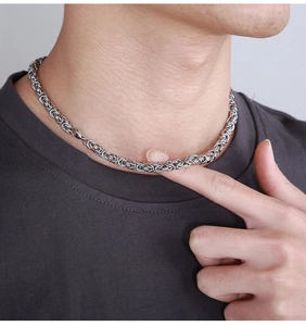 Close-up of men's silver Byzantine chain necklace with intricate interlocking metal links