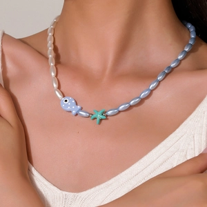 Dettaglio della collana di perline con ciondoli a forma di pesce e stella marina