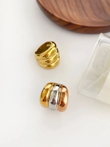 Detailed macro of 18K gold plated triple-layered wave ring and tricolor stacked band