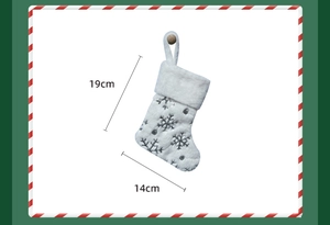 Dettaglio calza di Natale in peluche bianco con motivi a fiocco di neve argento 19x14cm