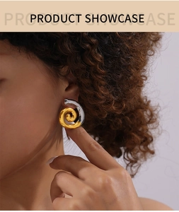 Détail de boucles d'oreilles spirales géométriques en or et argent sur mannequin
