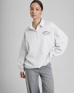Detail of letter print on light grey polo collar sweatshirt with soft cotton texture