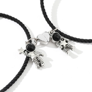 Detail shot of magnetic astronaut charms with woven adjustable cords on white backdrop