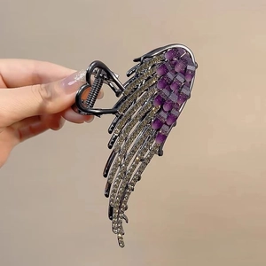 Detailed shot of silver angel wing hair claw clip with purple rhinestones and opal stones