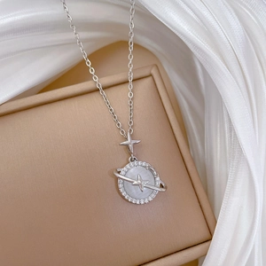 Macro detail of silver planet pendant necklace featuring cat eye stone and cubic zirconia