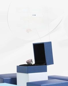 Detail of open blue leatherette ring box with black velvet lining and jewelry