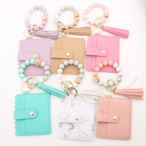 Flat lay of macaron-colored silicone bead bracelets with PU leather card holders and tassels